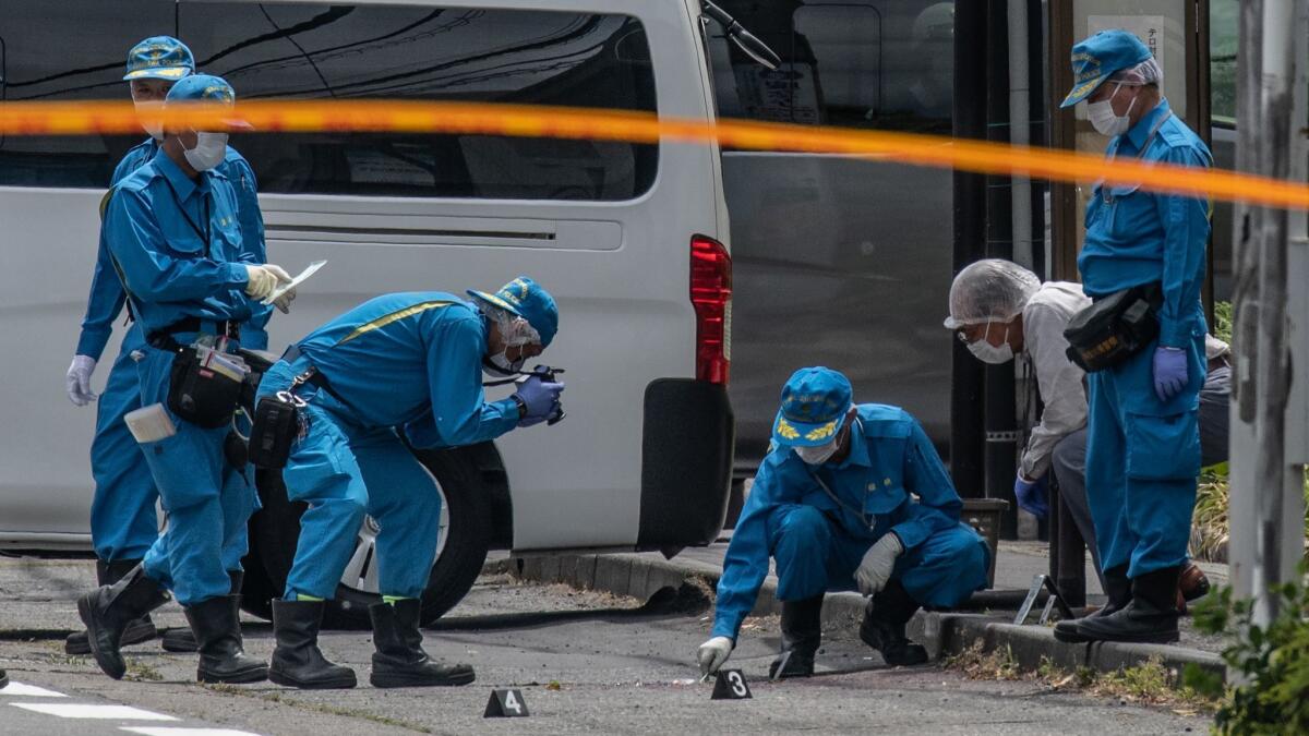 Police forensics officers work at the scene of a mass stabbing May 28 in Kawasaki, Japan.