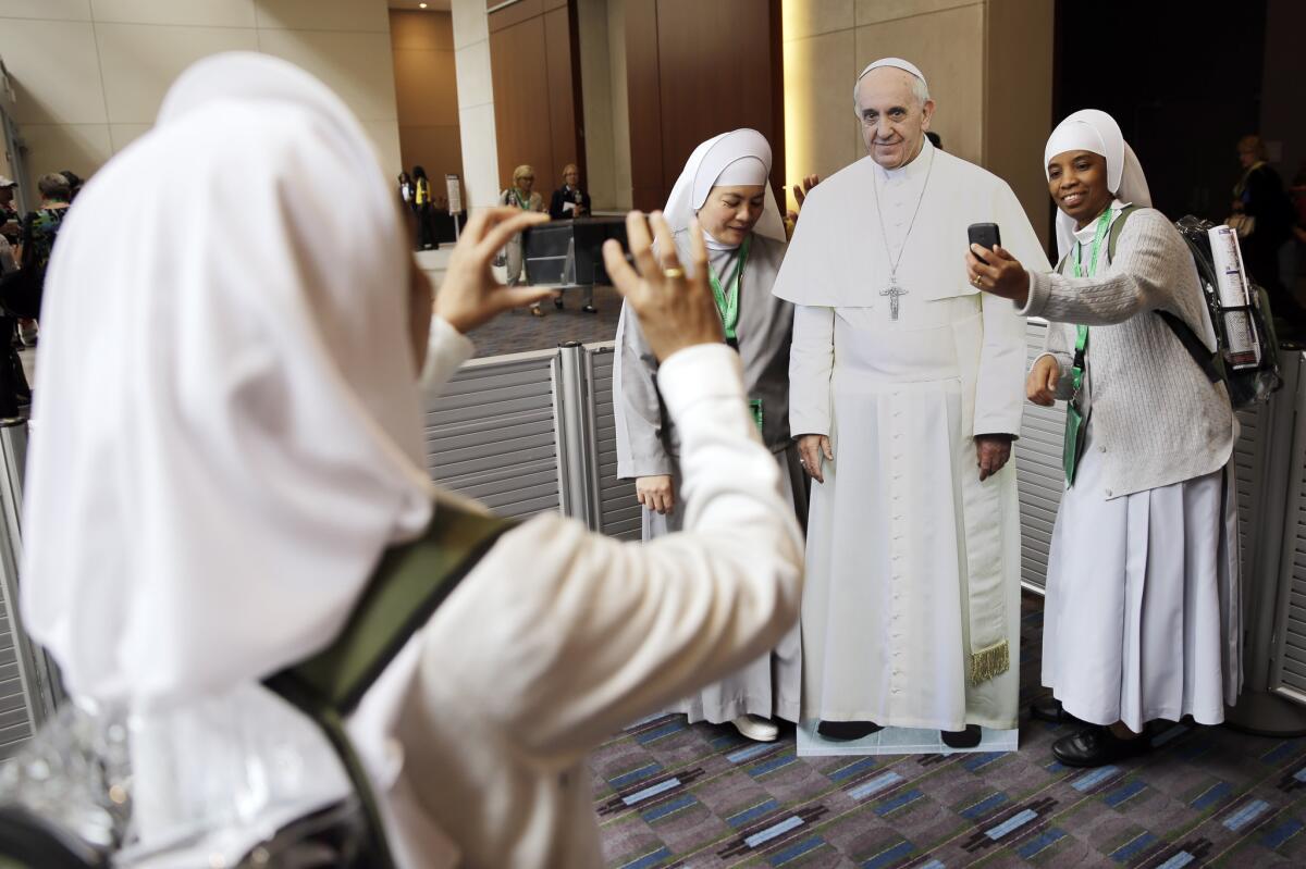 Nuns with the Hospitaler Sisters of Mercy in Pleasantville, N.J., pose for a selfie with a cutout of Pope Francis at the World Meeting of Families conference in Philadelphia on Tuesday.