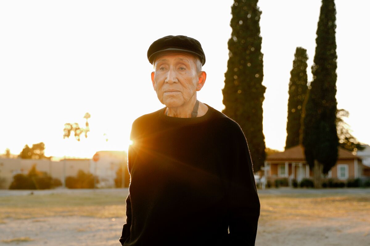A man stands in front of trees