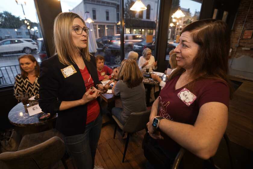 Kelly Dillaha, left, talks with Kathy Nitz during a Red Wine and Blue event in Utica, Mich., Tuesday, Sept. 20, 2022. (AP Photo/Paul Sancya)