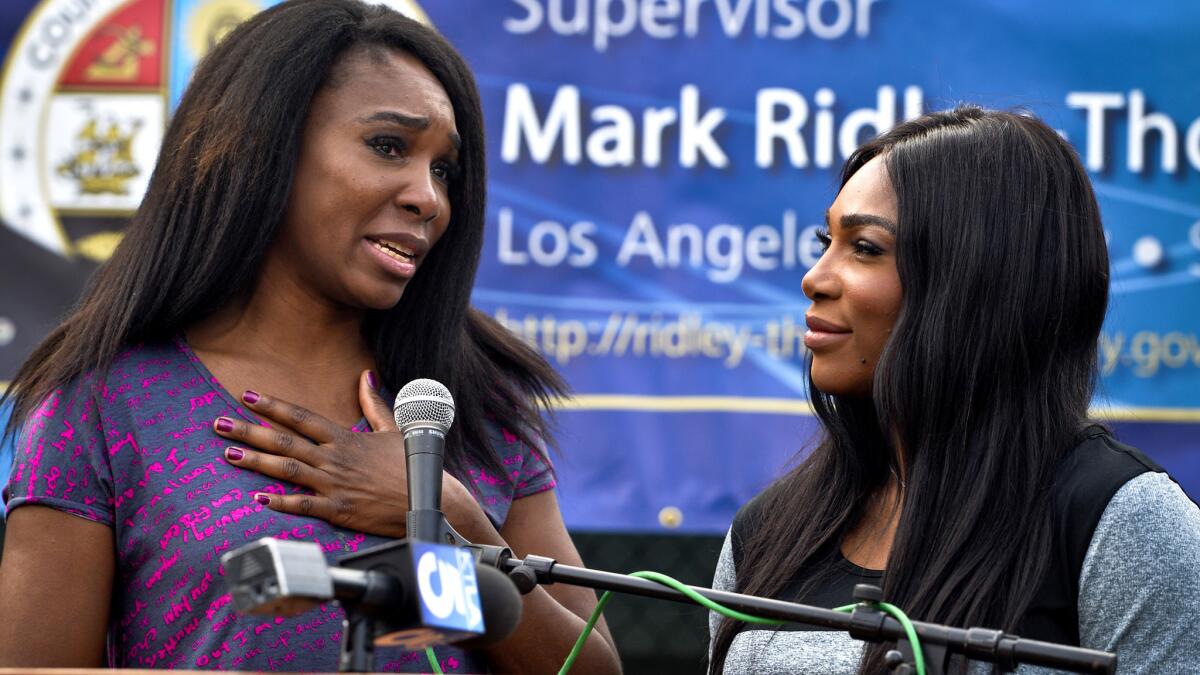 Sisters Venus, left, and Serena Williams speak at the opening ceremony for new tennis courts at East Rancho Dominguez County Park in Compton on Saturday.