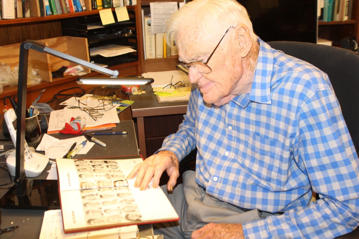 La Jolla resident Harry Crosby, 94, scans his 1942 La Jolla High yearbook, wondering what happened to a close friend.