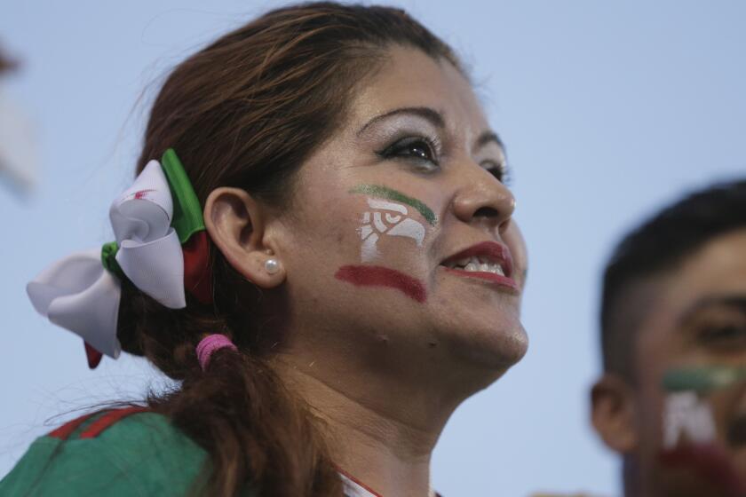 A Mexico fan cheers her team during the first half of a CONCACAF Gold Cup soccer match against Trinidad & Tobago in Charlotte, N.C., Wednesday, July 15, 2015. (AP Photo/Chuck Burton)