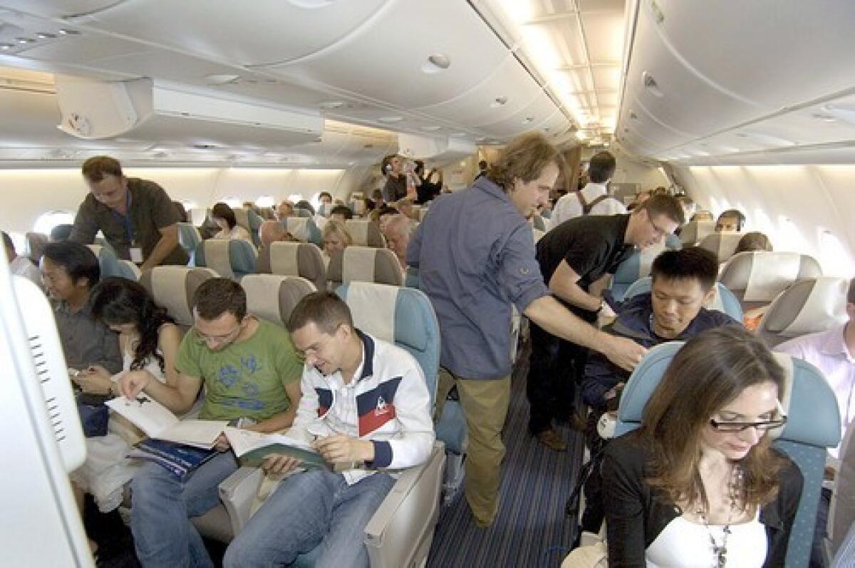 Passengers sit in the main deck of the Singapore Airlines Airbus A380 Economy Class during its first commercial flight from Singapore to Sydney. The Airbus A380 replaces the Boeing Jumbojet 747 as largest passenger aircraft, whose maiden flight was in 1970 from New York to London.