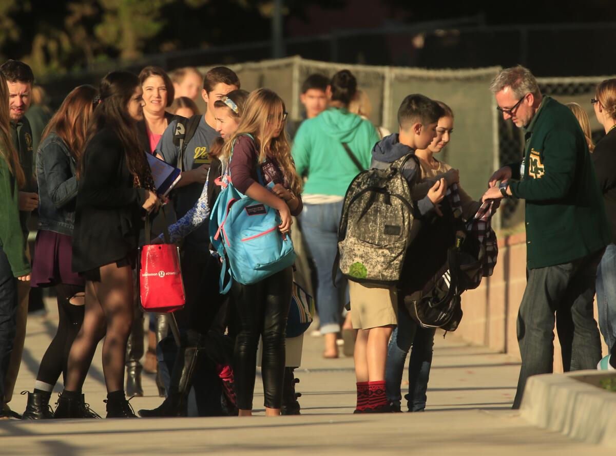 Students' bags are inspected at Mira Costa High School in Manhattan Beach, one of the security measures taken after online threats were posted against the school.