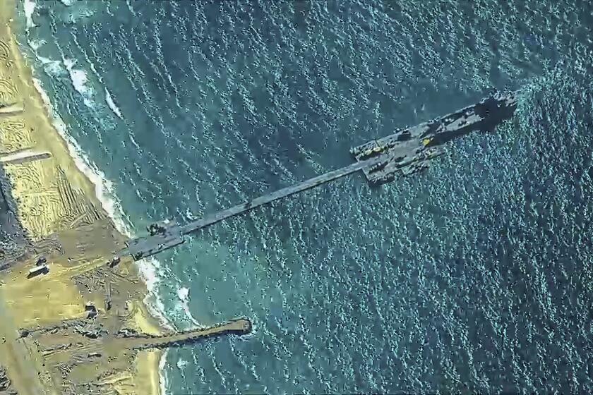 The image provided by U.S, Central Command, shows U.S. Army soldiers assigned to the 7th Transportation Brigade (Expeditionary), U.S. Navy sailors assigned to Amphibious Construction Battalion 1, and Israel Defense Forces placing the Trident Pier on the coast of Gaza Strip on Thursday, May 16, 2024. The temporary pier is part of the Joint Logistics Over-the-Shore capability. The U.S. military finished installing the floating pier on Thursday, with officials poised to begin ferrying badly needed humanitarian aid into the enclave besieged over seven months of intense fighting in the Israel-Hamas war. (U.S. Central Command via AP)