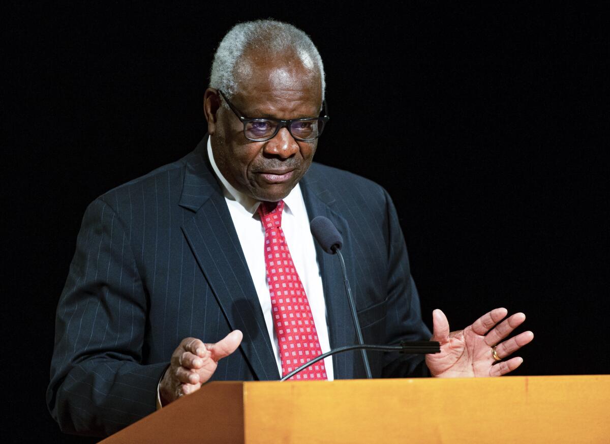 Supreme Court Justice Clarence Thomas speaks at a lectern