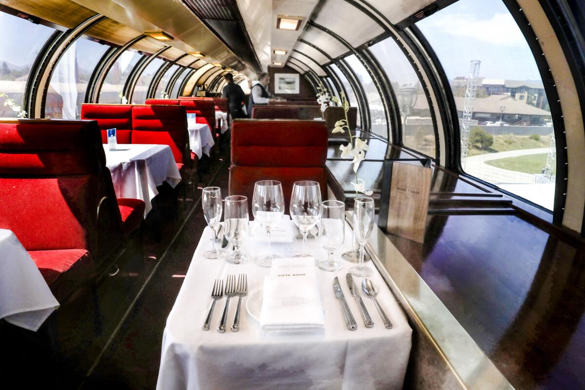 Inside the dining car of a luxury train, with large windows for looking out