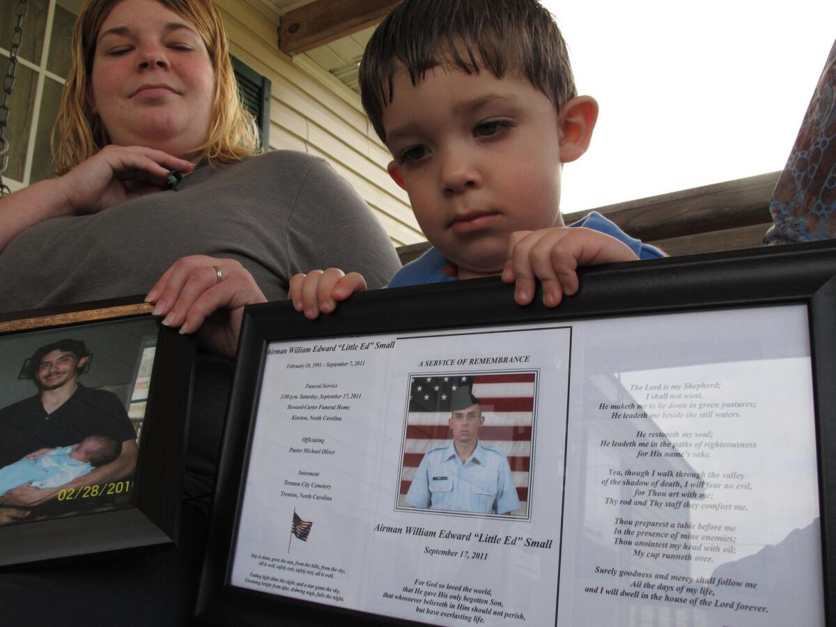 Shane Mercer points to a photo of his father, Airman Will Small, as his mother Alecia Mercer looks on at their home in Kinston, N.C. Small, whose organs were donated to four patients after he died, had at least two untreated raccoon bites several months before he became sick, and tests confirm his rabies-infected kidney led to a recipient's death.
