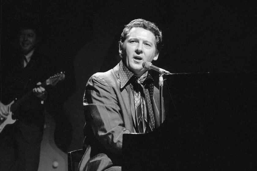 American rockabilly performer Jerry Lee Lewis plays the piano and sings as he appears on the CBS variety program 'The Ed Sullivan Show,' New York, November 16, 1969. Behind him, in the shadows, a man accompanies him on guitar. (Photo by CBS Photo Archive/Getty Images) ** OUTS - ELSENT, FPG, CM - OUTS * NM, PH, VA if sourced by CT, LA or MoD ** "The Killer," Jerry Lee Lewis, circa 1969, happy the Doors are elsewhere.