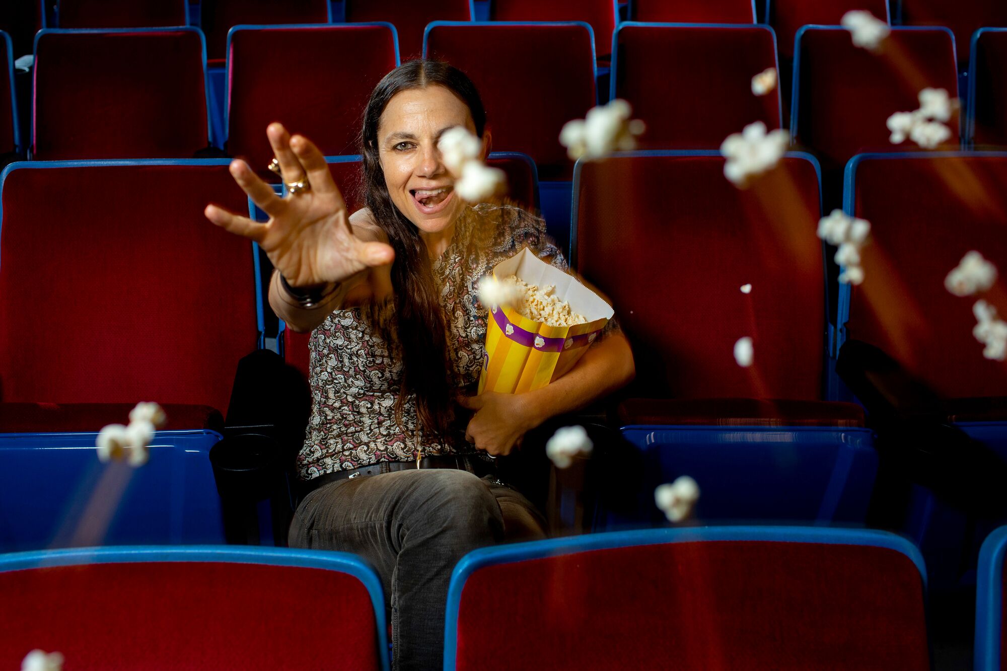 March 5: Actress and writer Justine Batemen sits in a movie theater and throws popcorn in front of her
