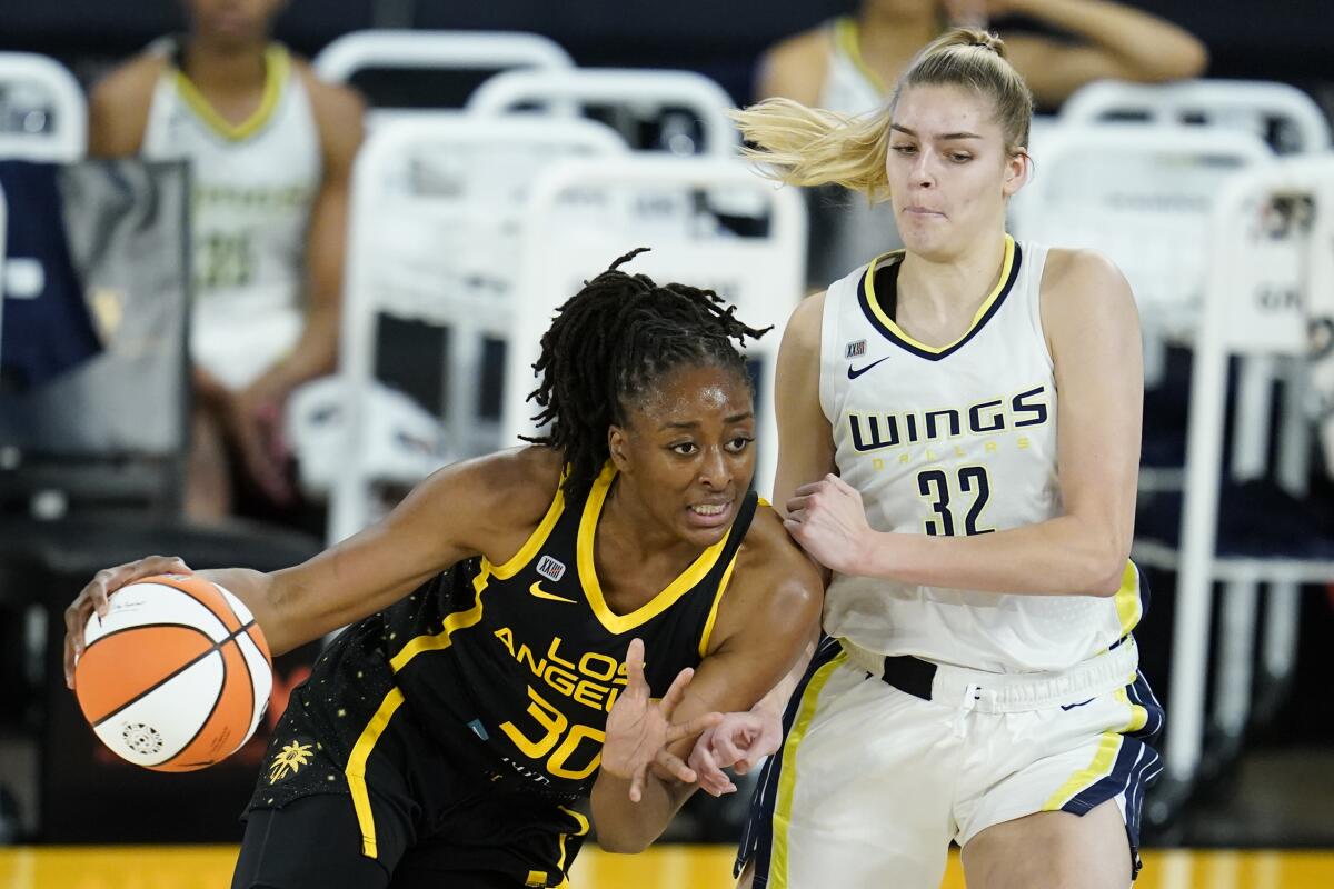 Los Angeles Sparks forward Nneka Ogwumike drives past Dallas Wings center Bella Alarie 