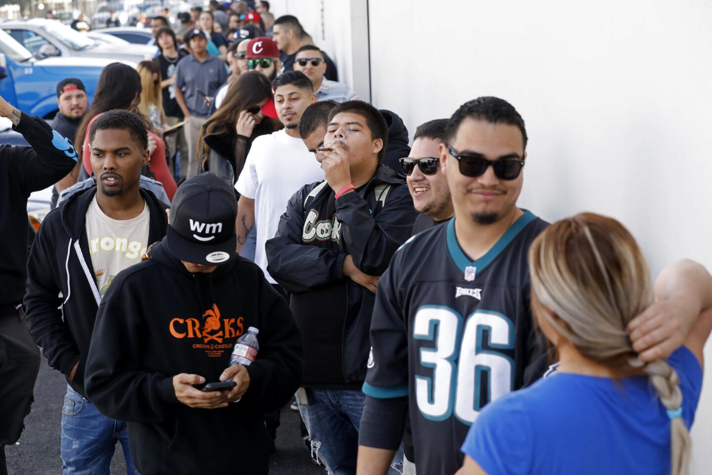 Anthony Ramirez, center, of Culver City, waits in line at the grand opening of Cookies Los Angeles, the city's first marijuana dispensary selling recreation use cannabis under Proposition 64.