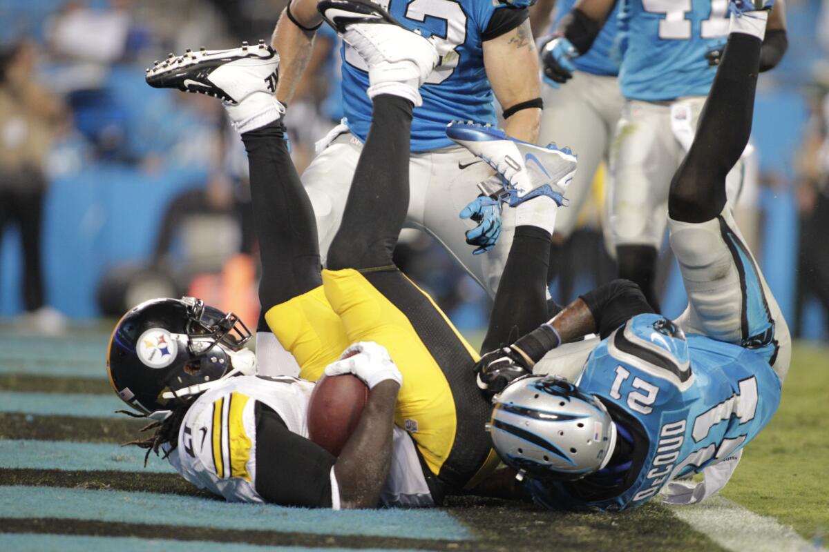 The Pittsburgh Steelers' LeGarrette Blount rolls into the end zone for a touchdown as the Carolina Panthers' Thomas DeCoud defends during their game in Charlotte, N.C., on Sept. 21.