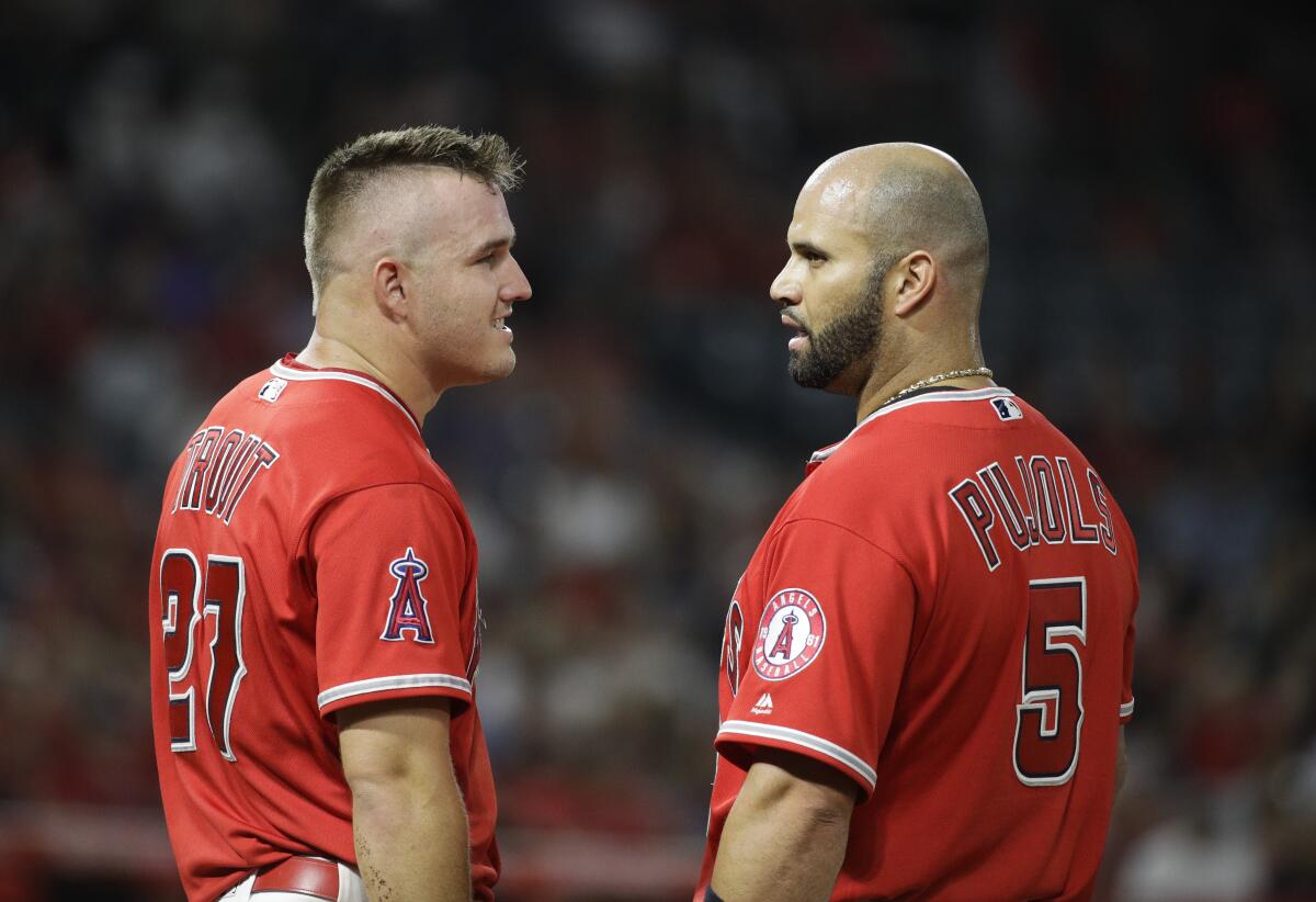 The Angels' Mike Trout, left, chats with Albert Pujols during a game Aug. 30, 2017.