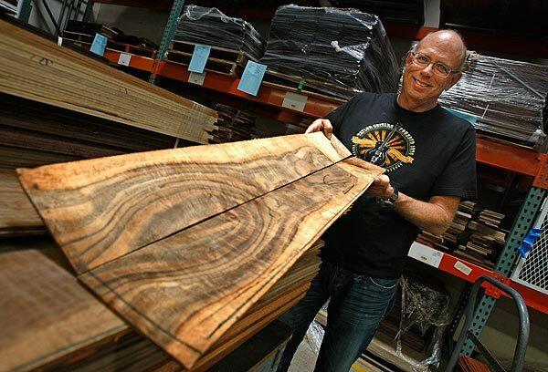 Bob Taylor, co-founder of Taylor Guitars in El Cajon, Calif., shows the beautiful grain pattern of walnut from Central California. The wood will be milled and shaped into the sides of acoustic guitars.