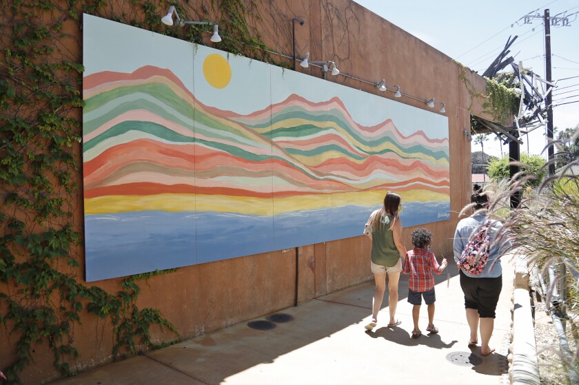 An exterior mural painted by Gabriella Kohr lines a pathway at the LAB Anti-Mall in Costa Mesa. 