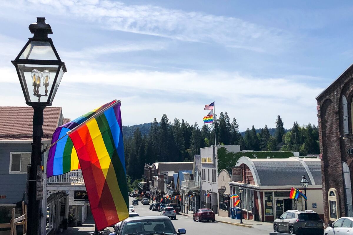Rainbow flags fly along a small downtown street