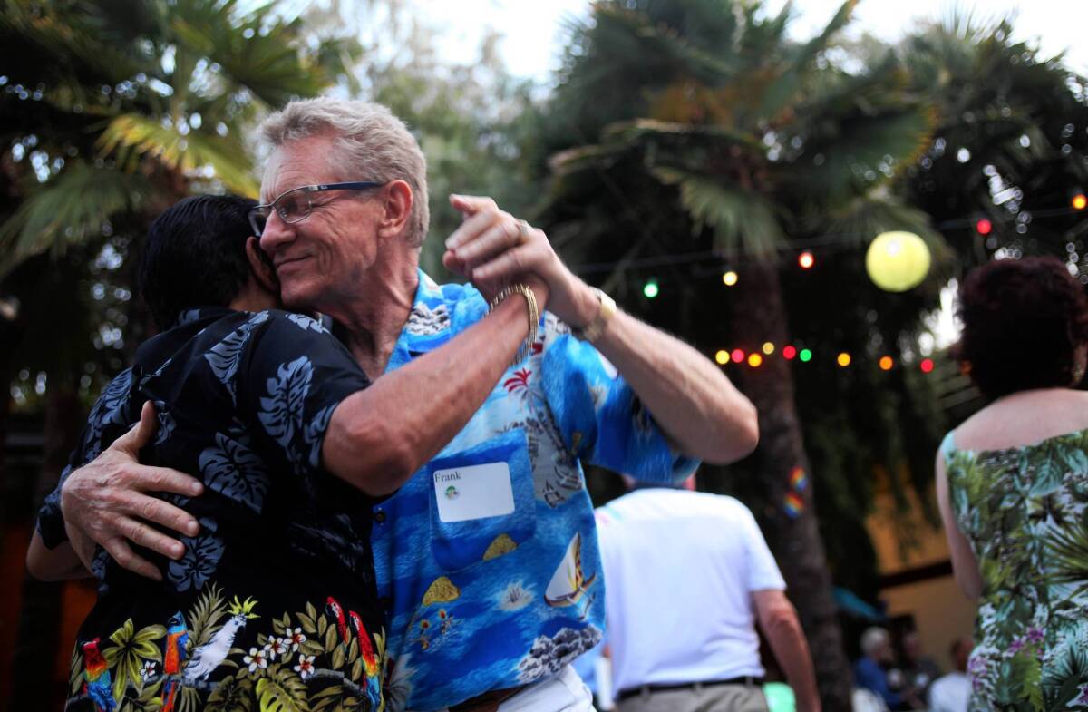 Frank Shoufer, right, dances with Robert Meza at the L.A. Gay and Lesbian Center's prom in Hollywood. Promgoers walked on a red carpet as part of the event, whose theme was "Come Fly With Me."