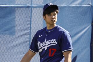 Dodgers' Shohei Ohtani walks around the second day of spring training in Phoenix on Feb. 15, 2024.