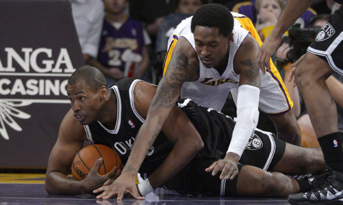 Brooklyn Nets center Jason Collins, left, battles for a loose ball with Lakers guard MarShon Brooks during the first half of Sunday's game at Staples Center.