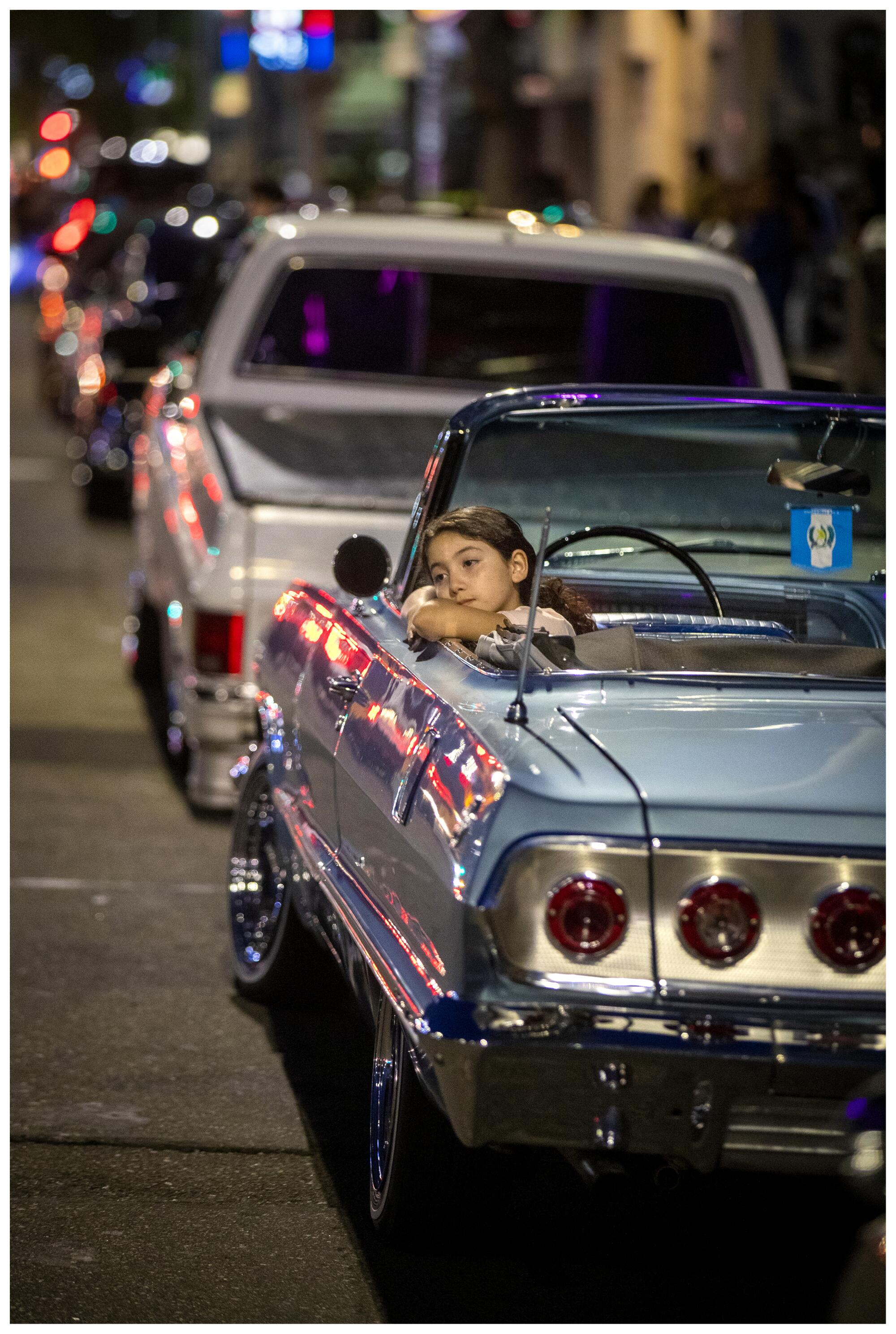 Karla Ramirez, 8, sits in her family's 1963 Chevrolet Impala Super Sport during Van Nuys Cruise Night.