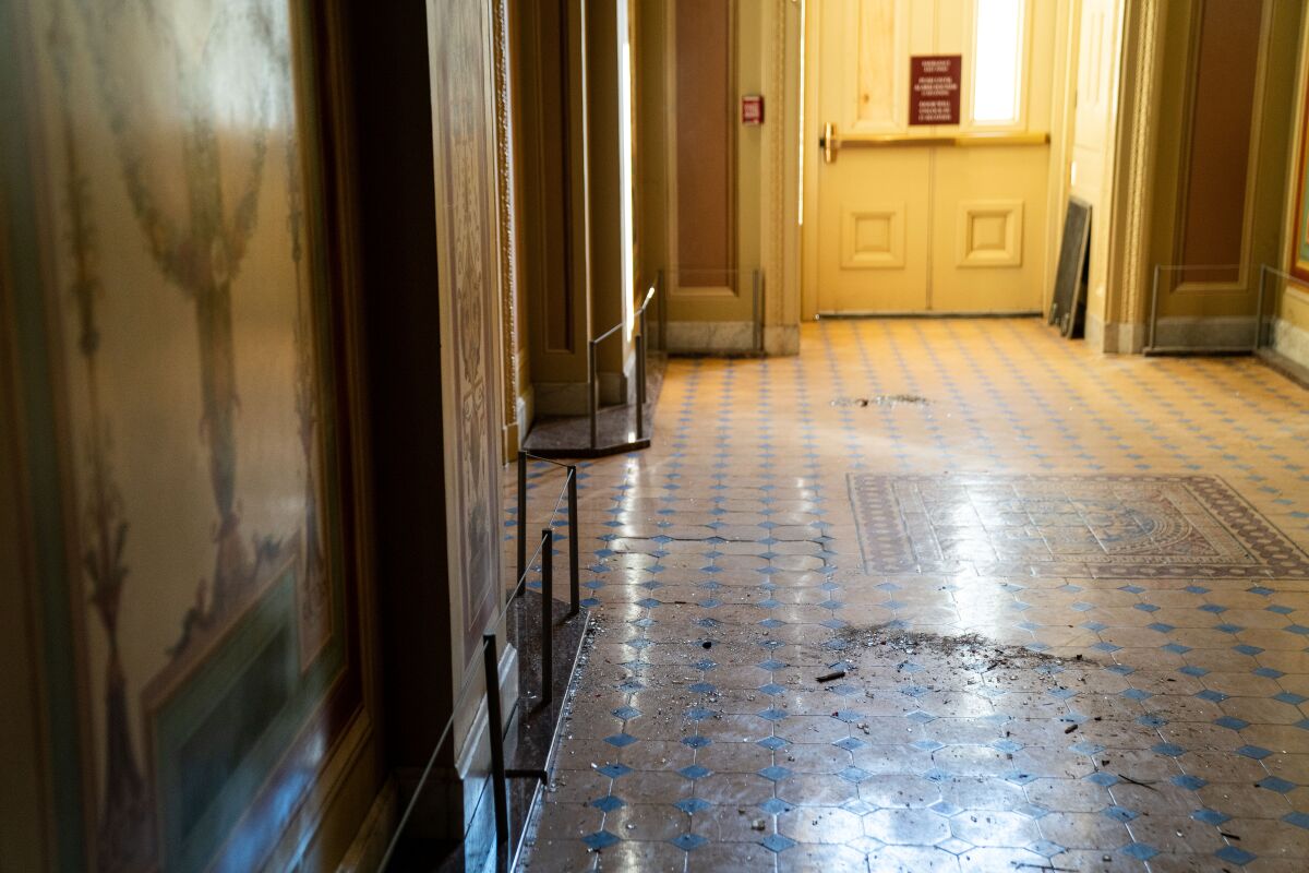 Broken glass and debris on a floor inside the Capitol.