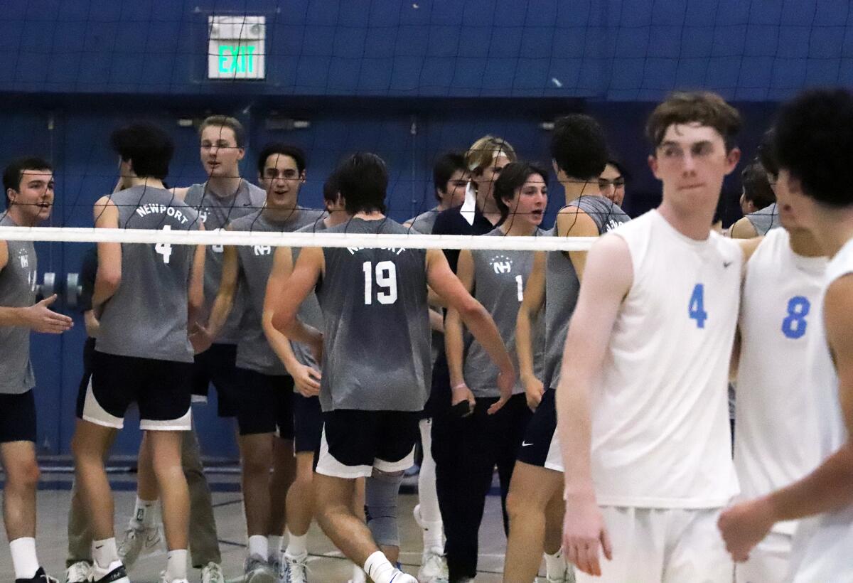 Newport Harbor's boys' volleyball team celebrates after winning a set against Corona del Mar on Friday.