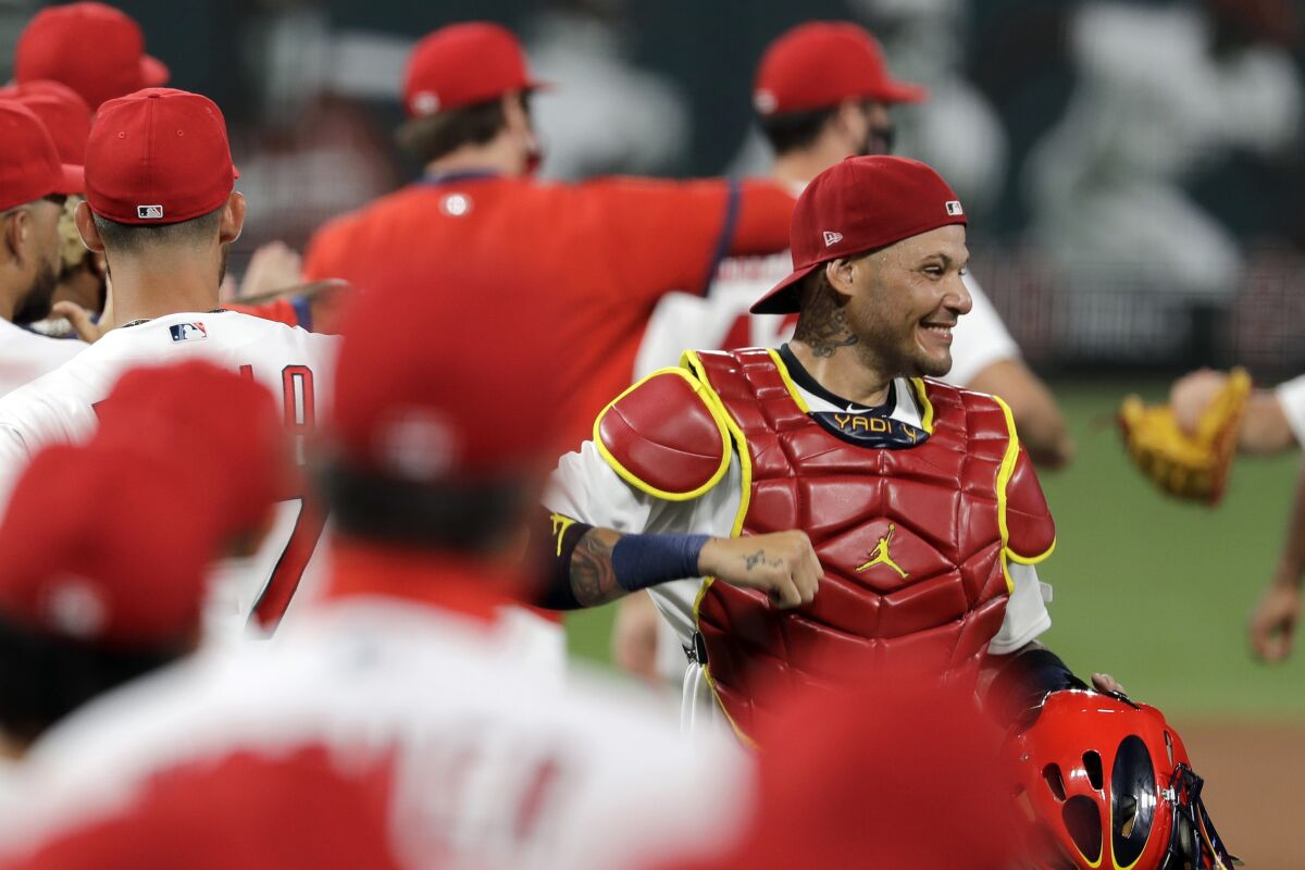 FILE - In this Friday, July 24, 2020, file photo, St. Louis Cardinals catcher Yadier Molina, right, celebrates a 5-4 win over the Pittsburgh Pirates in a baseball game in St. Louis. Molina says he’s one of the players on his team who has tested positive for the coronavirus. The nine-time All-Star revealed his diagnosis Tuesday, Aug. 4, 2020, in a Spanish-language Instagram post. (AP Photo/Jeff Roberson, File)