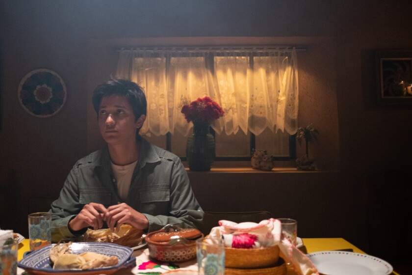 A man sits at a table that's laden with food.