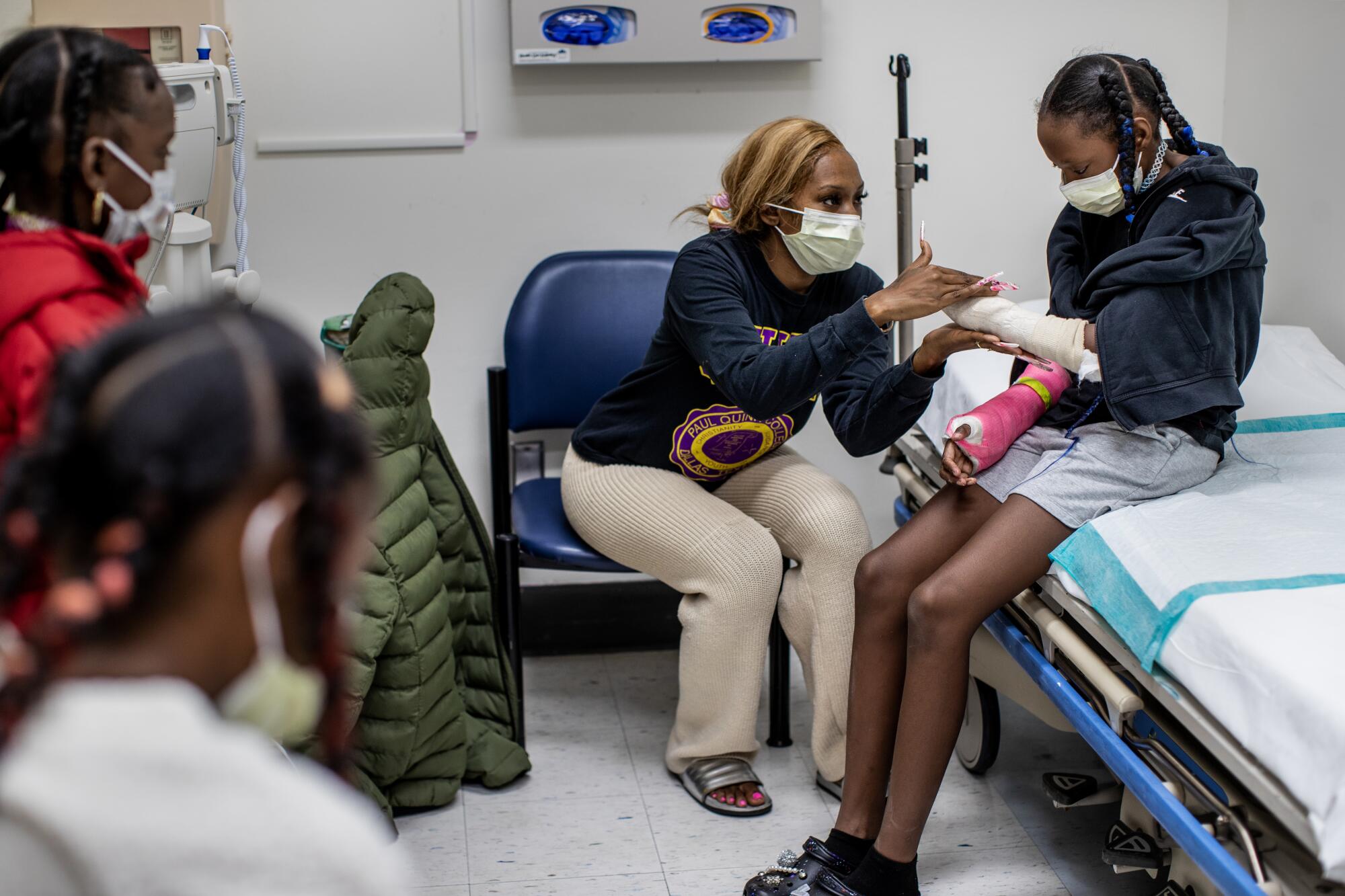 Staneisha Matthews rubs her daughter La'Veyah Mosley's, 12, left hand before a doctors appointment 