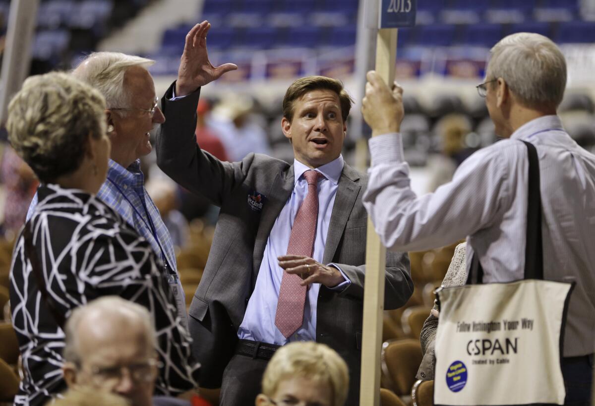 FILE - In this May 17, 2013, file photo, candidate for Governor of Virginia, Pete Snyder, center, gestures as he talks to delegates during the opening of the Virginia Republican convention in Richmond, Va. The top GOP contenders for governor in Virginia say “election integrity” is a high priority. The candidates say change is needed to restore credibility to the voting process, whether that involves tightening voter ID laws, making the Department of Elections politically independent, or cleaning up voter rolls. (AP Photo/Steve Helber, File)