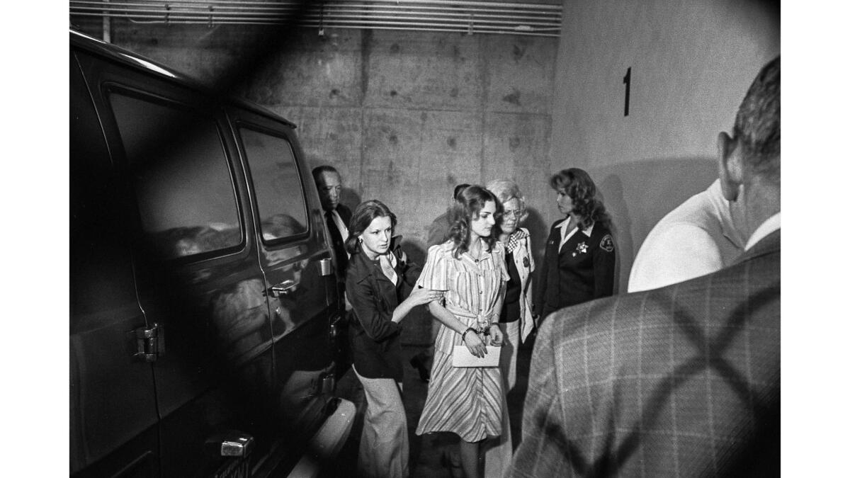 Patty Hearst, shown in handcuffs, is escorted by two women near the inmate entrance of the criminal court building in Los Angeles, on May 28, 1976. 