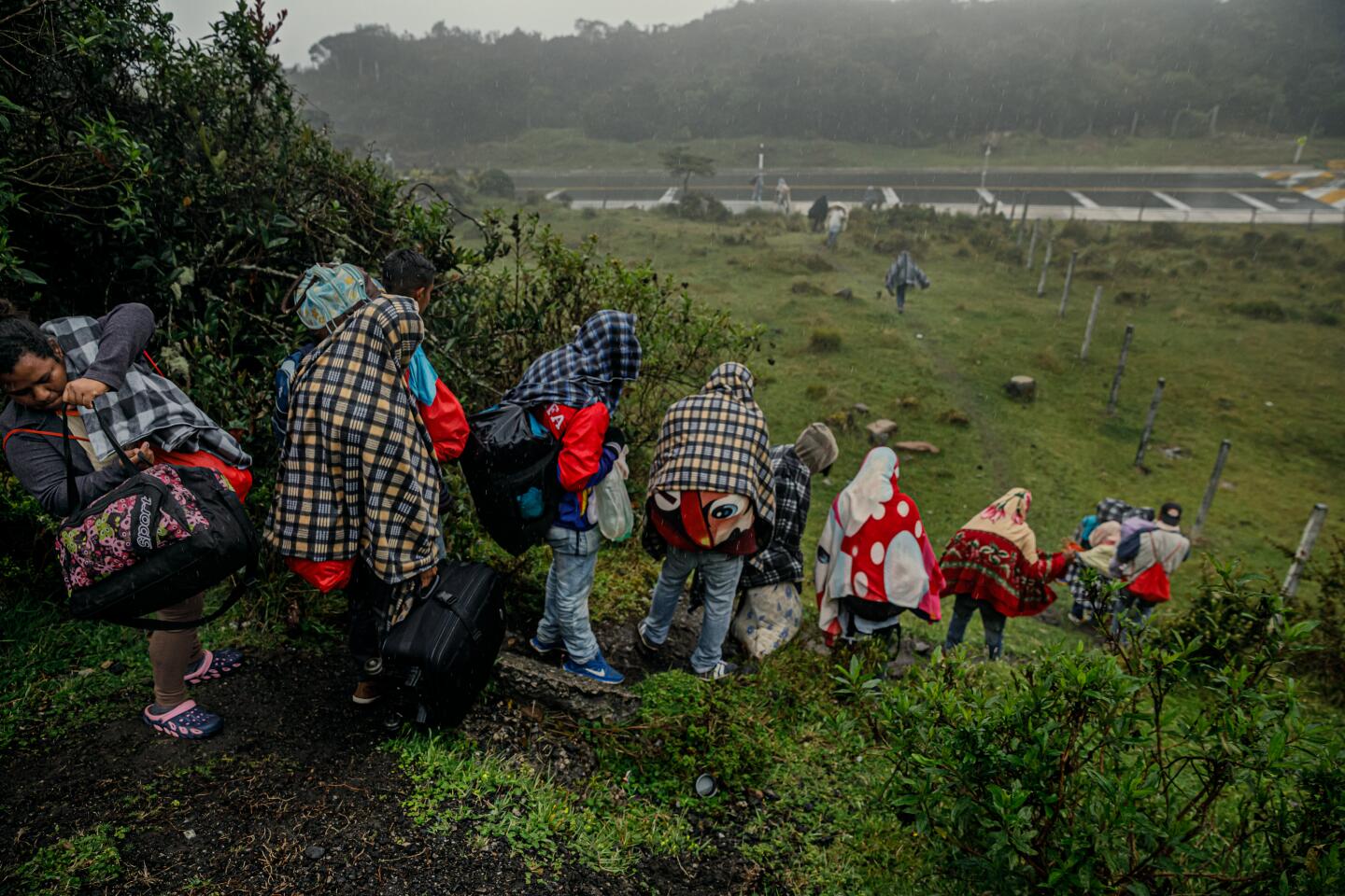Venezuelan migrants walk through rain and cold.