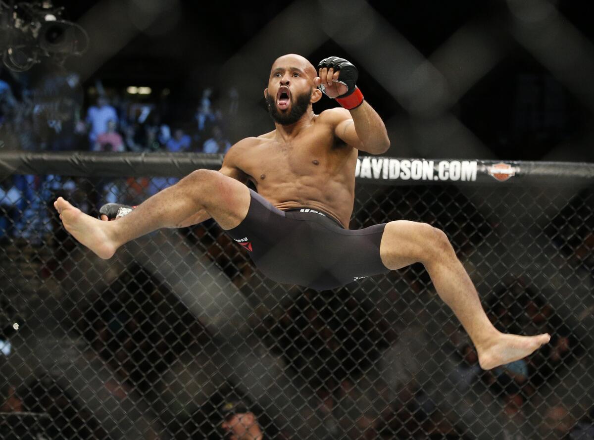 Demetrious Johnson celebrates after defeating Henry Cejudo in a flyweight championship bout at UFC 197 on April 23.