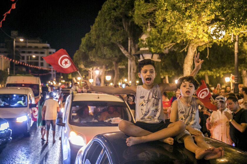 Tunisians celebrate the exit polls indicating a vote in favor of the new Constitution, in Tunis, late Monday, July 25, 2022. Hundreds of supporters of Tunisian President Kais Saied took to the streets to celebrate after the end of voting on a controversial new constitution that critics say could reverse hard-won democratic gains and entrench a presidential power grab. (AP Photo/Riadh Dridi)