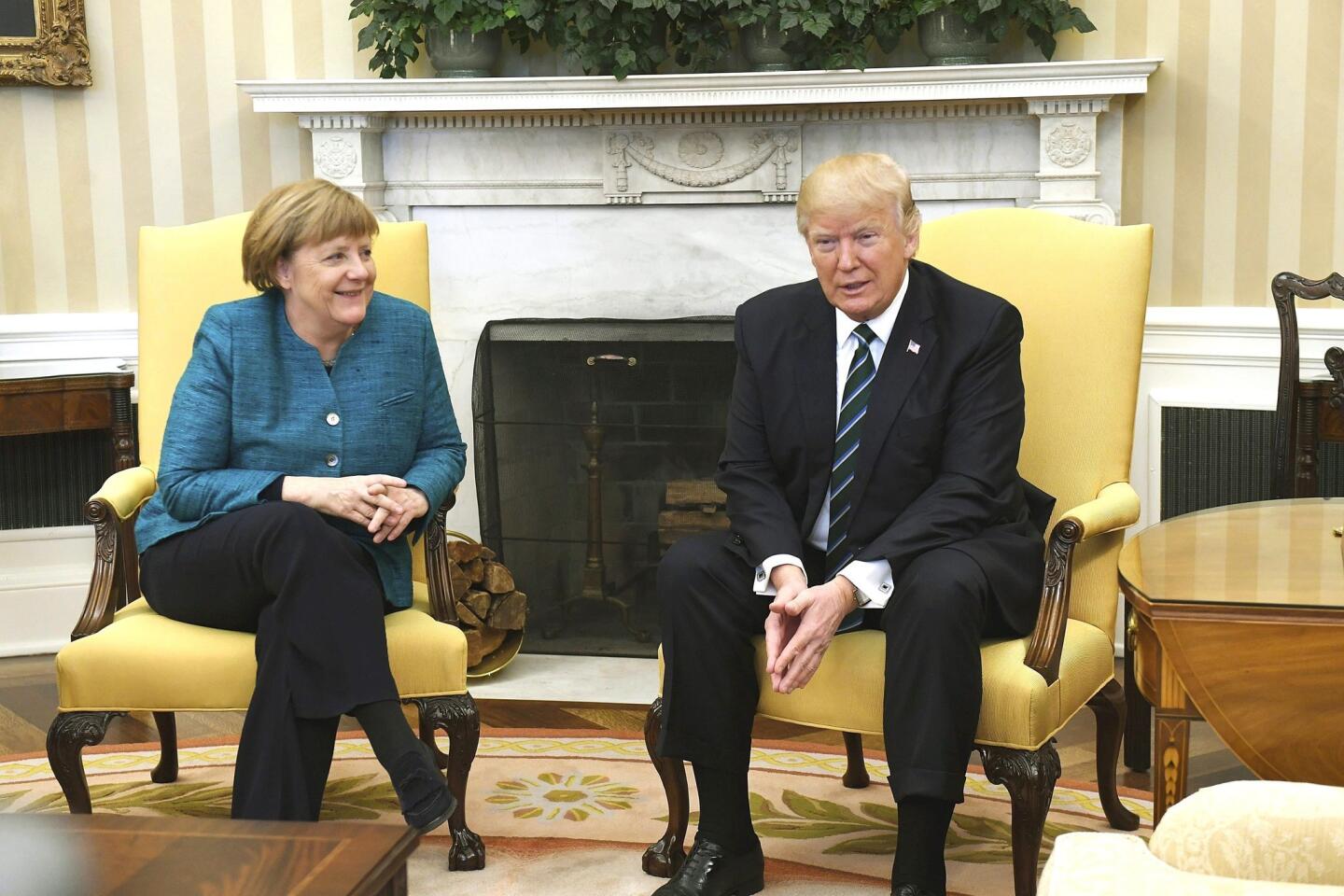 La canciller alemana, Angela Merkel (i), sonríe ante la petición de los fotógrafos de darse la mano con el presidente de EEUU, Donald J. Trump, en su reunión en el Despacho Oval de la Casa Blanca en Washington.