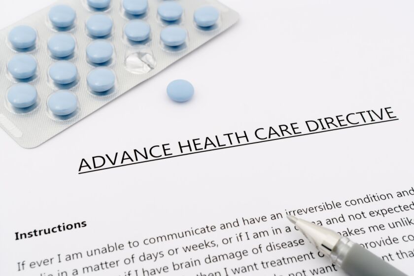 advance health care directive with blue pills ans grey pen on White paper