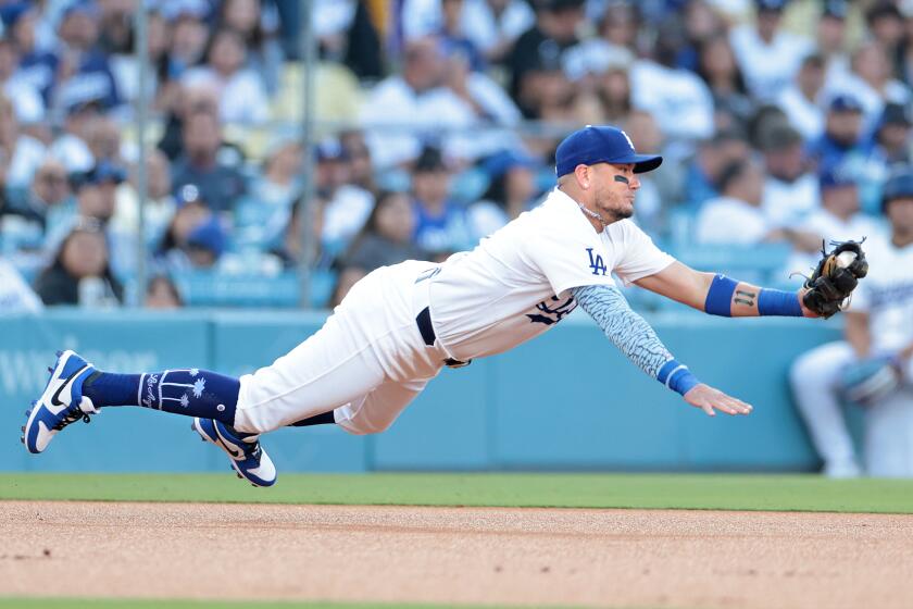 LOS ANGELES CALIFORNIA CALIFORNIA-Dodgers Miguel Rojas dives to make a catch for the out on Rangers Marcus Semien in the first inning at Dodgers Stadium Tuesday. (Wally Skalij/Los Angeles Times)