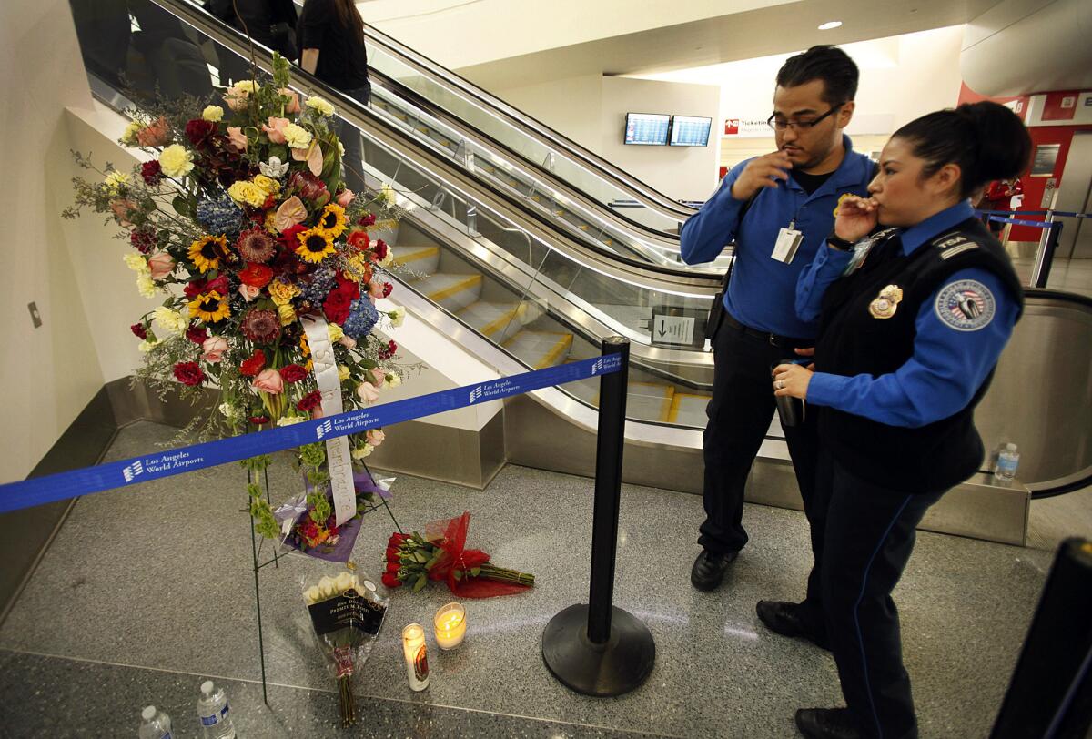Transportation Security Administration agents leave flowers and say a prayer at the site where TSA Officer Gerardo Hernandez was shot to death inside Terminal 3 at LAX.