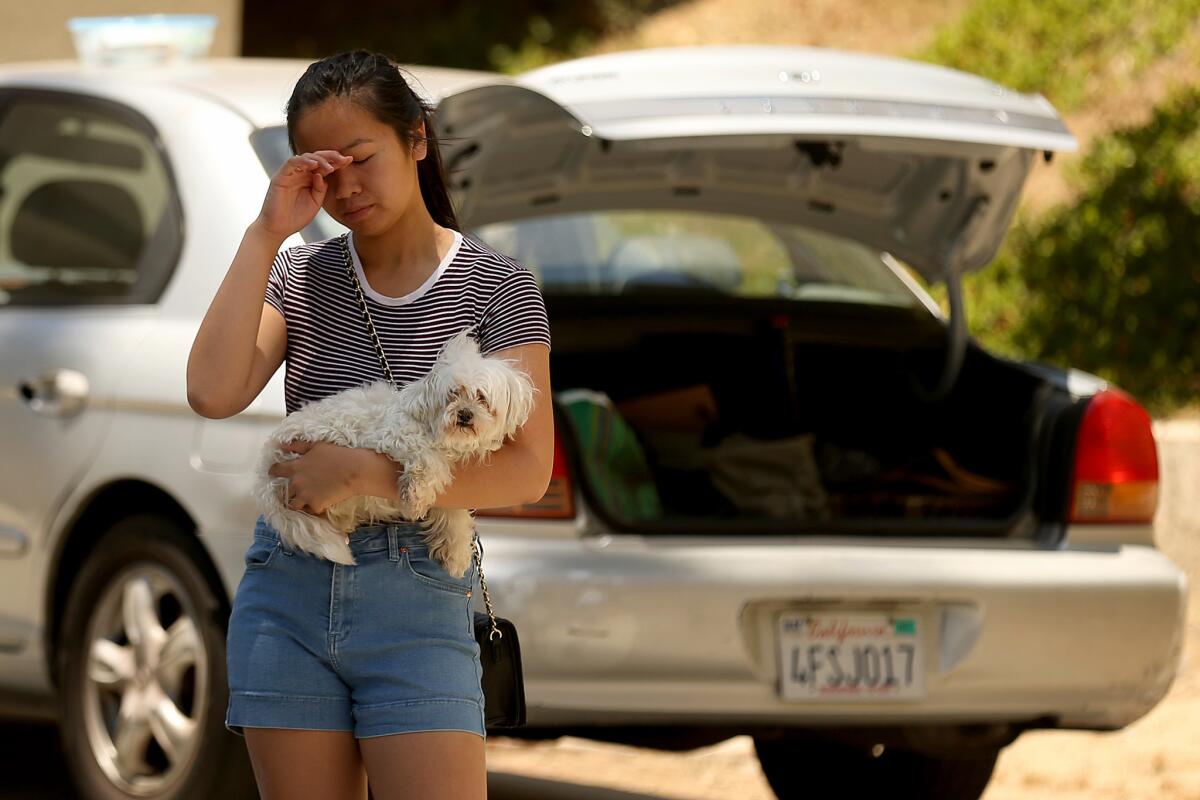 Connie Tran, 17, holds her dog Snowball as she prepares to evacuate her house with her family.