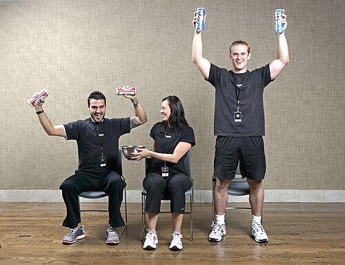 Equinox personal trainers Jeffery Scott, left, and Nik Herold, right, work their beer cans, while Megan Butacan passes chips.