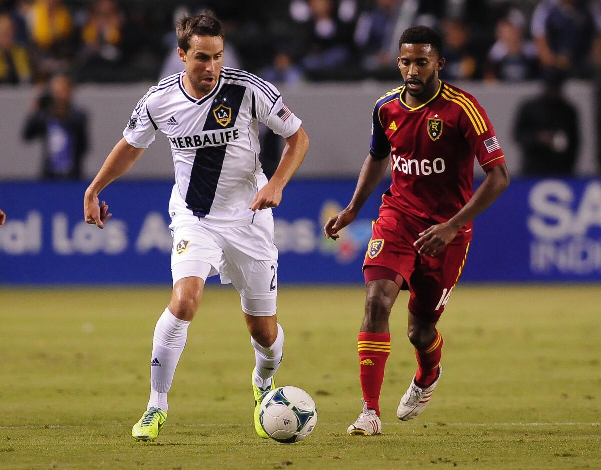 Real Salt Lake midfielder Yordany Alvarez attempts to steal the ball from Galaxy defender Todd Dunivant, left, during the first half of an MLS match on Nov. 3, 2013.