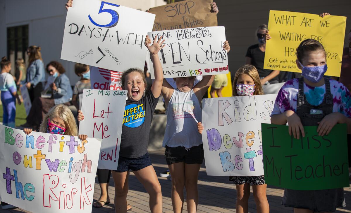 Students hold signs at a rally at the Huntington Beach City School District headquarters on Tuesday.
