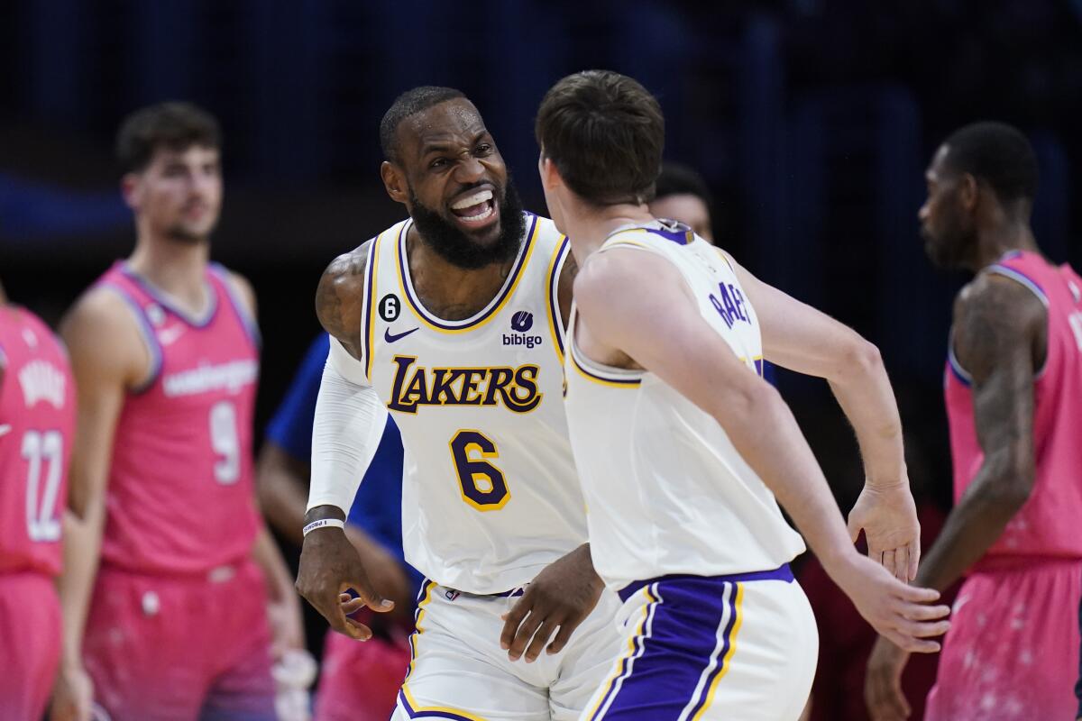 Los Angeles Lakers' LeBron James (6) celebrates with Austin Reaves (15) after making a basket.