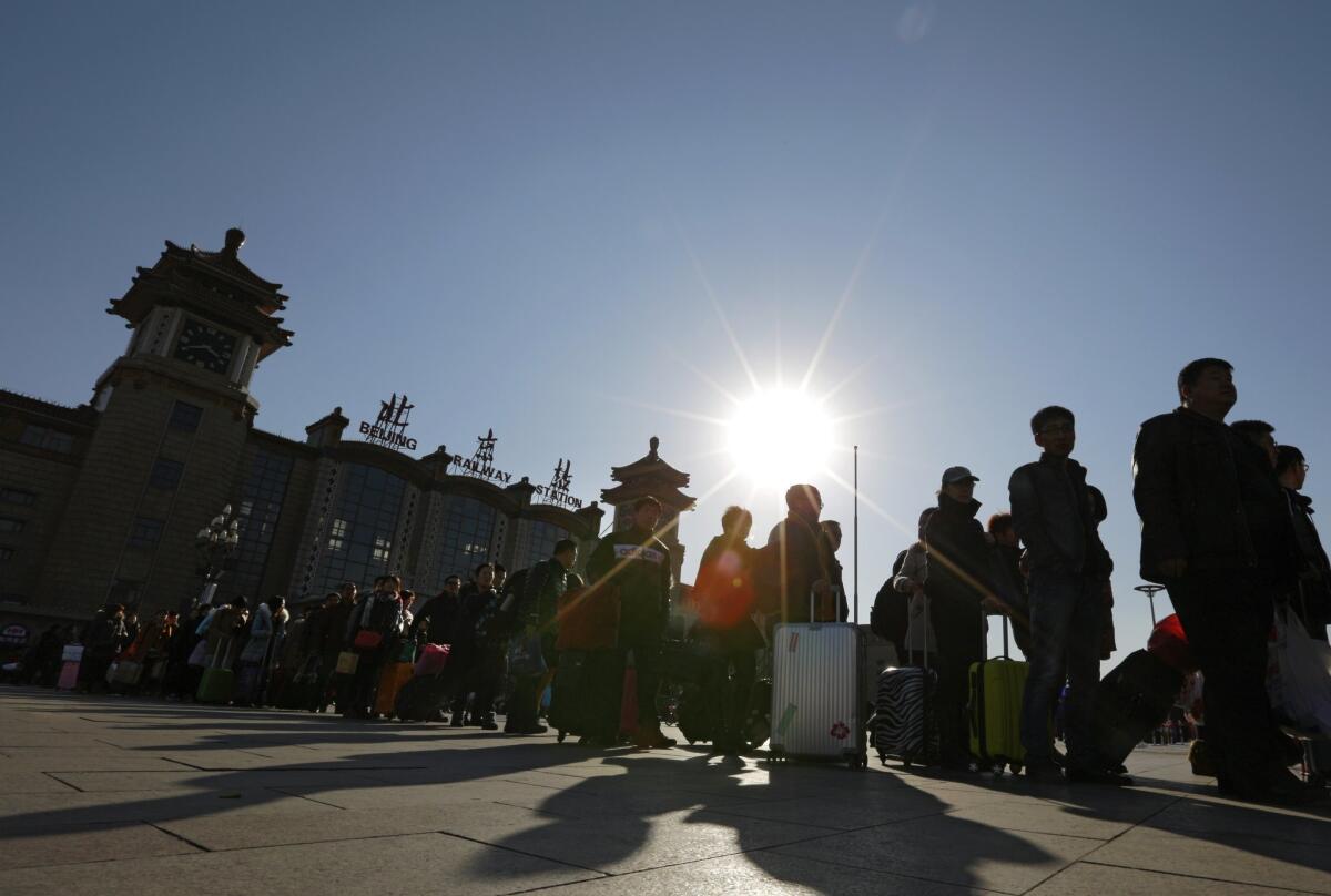 Passengers line up to get taxis at the Beijing railway station on Feb. 25.