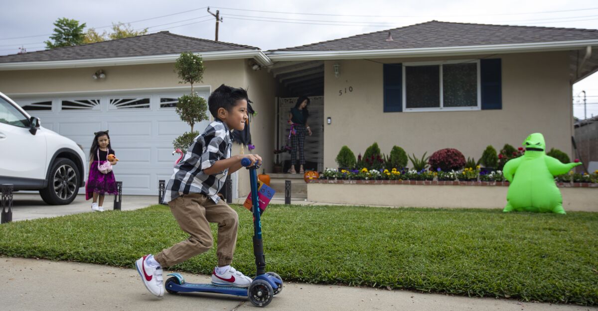 Noah Aguayo, 5, right, and his sister Ariel, 4, left, play in front of a house.