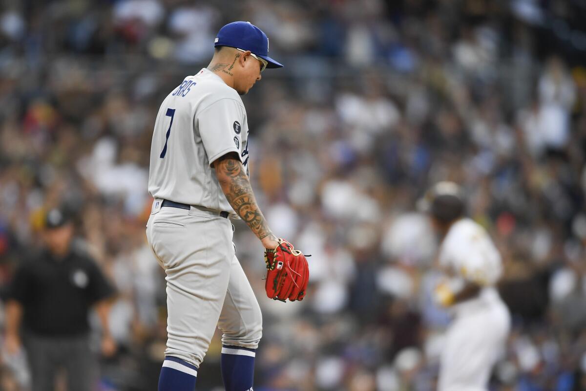 Dodgers pitcher Julio Urías looks down as the San Diego Padres' Manny Machado rounds the bases.