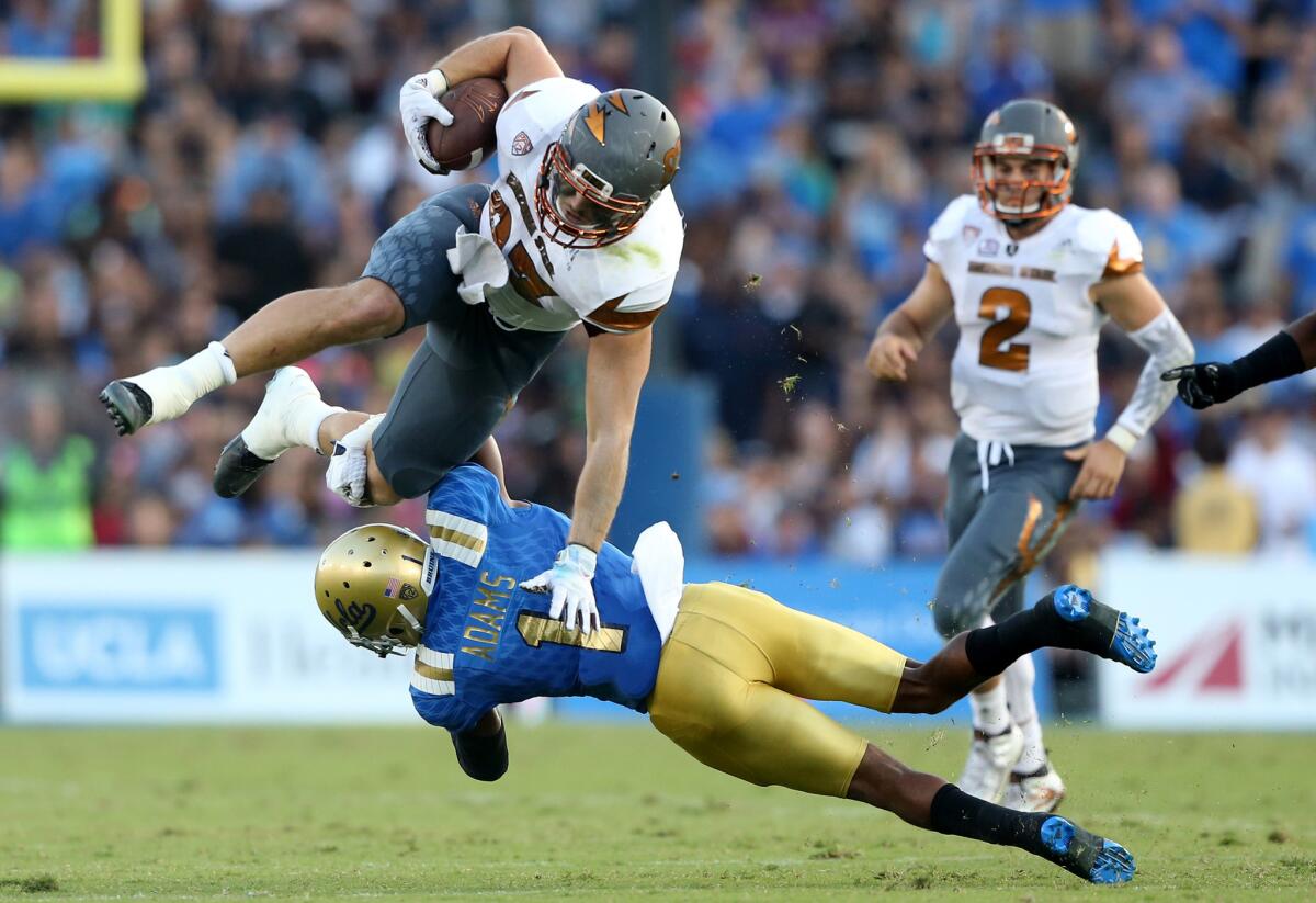 UCLA defensive back Ishmael Adams upends Arizona State tight end Kody Kohl late in the second quarter of a game at the Rose Bowl.