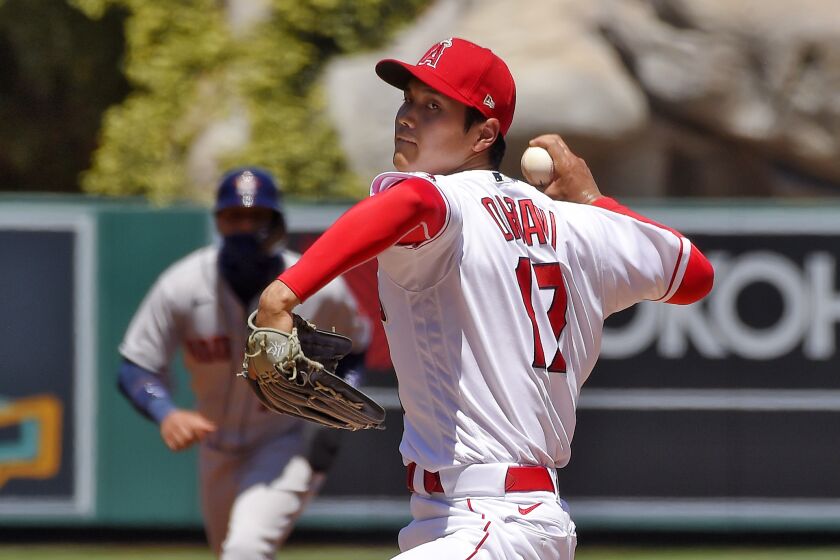 Los Angeles Angels pitcher Shohei Ohtani, right, of Japan, throws to the plate.